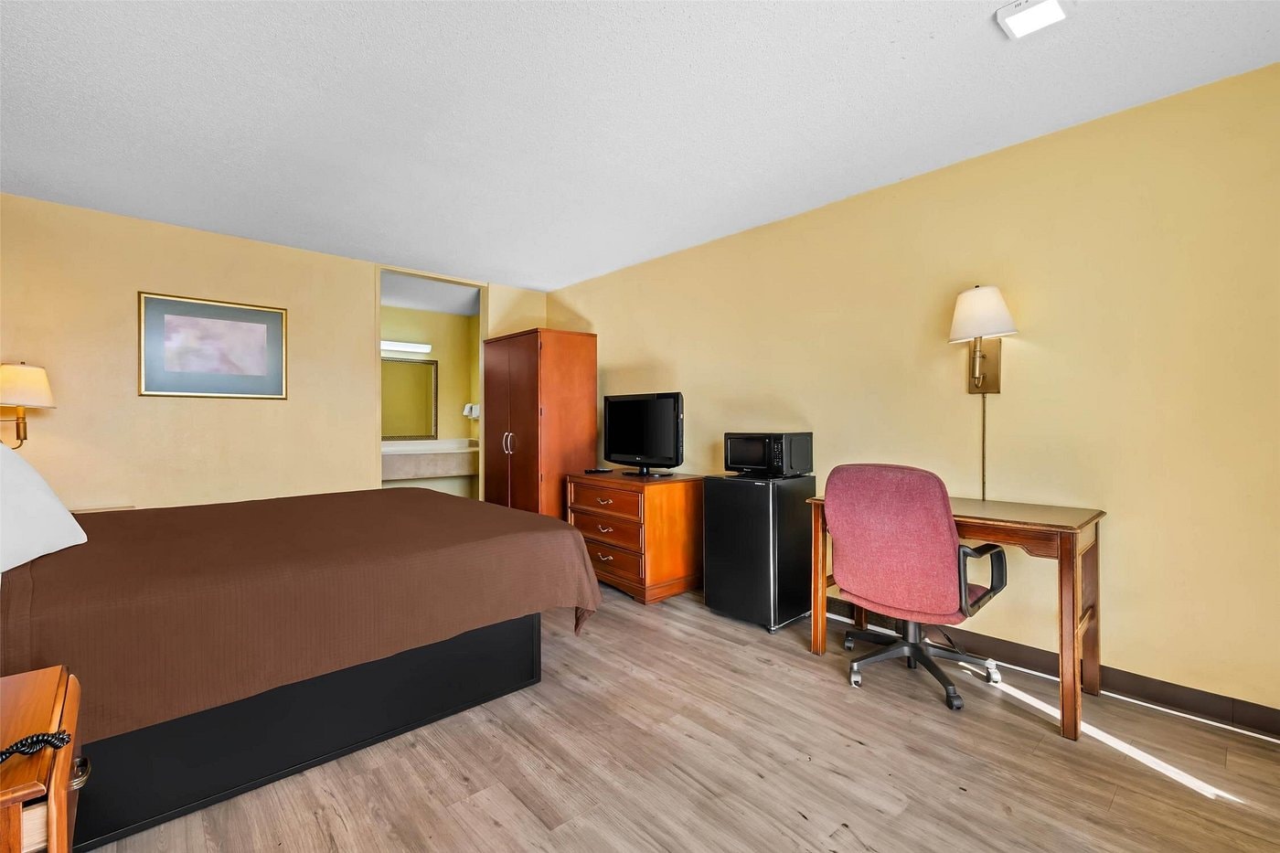Double queen room at Rodeway Inn Monroe — two beds, wood armoire, flat-screen TV, microwave and mini fridge